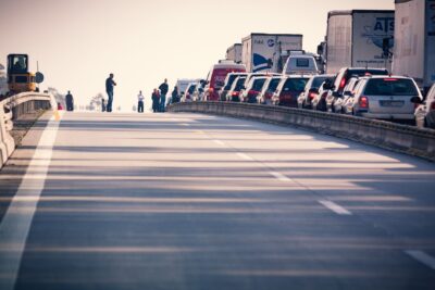 A congested highway with cars and trucks in a traffic jam during daylight. (photo Pexels)
